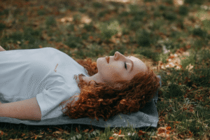 An image of a woman lying down on grass