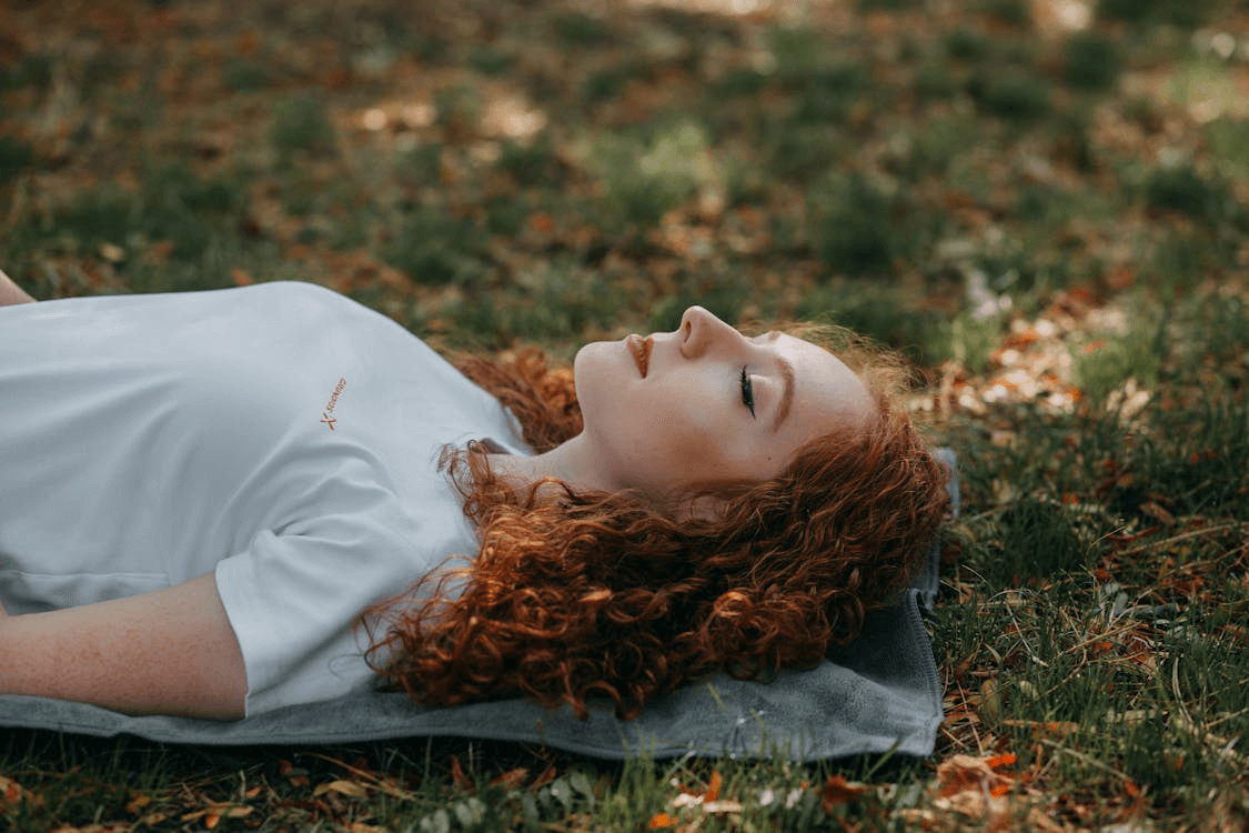 An image of a woman lying down on grass