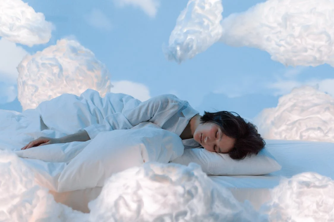 An animated image of a woman sleeping with clouds around her