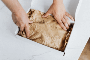 An image of a person packing a discreet parcel in a white box