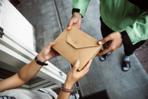 An image of a woman receiving a parcel in a brown box